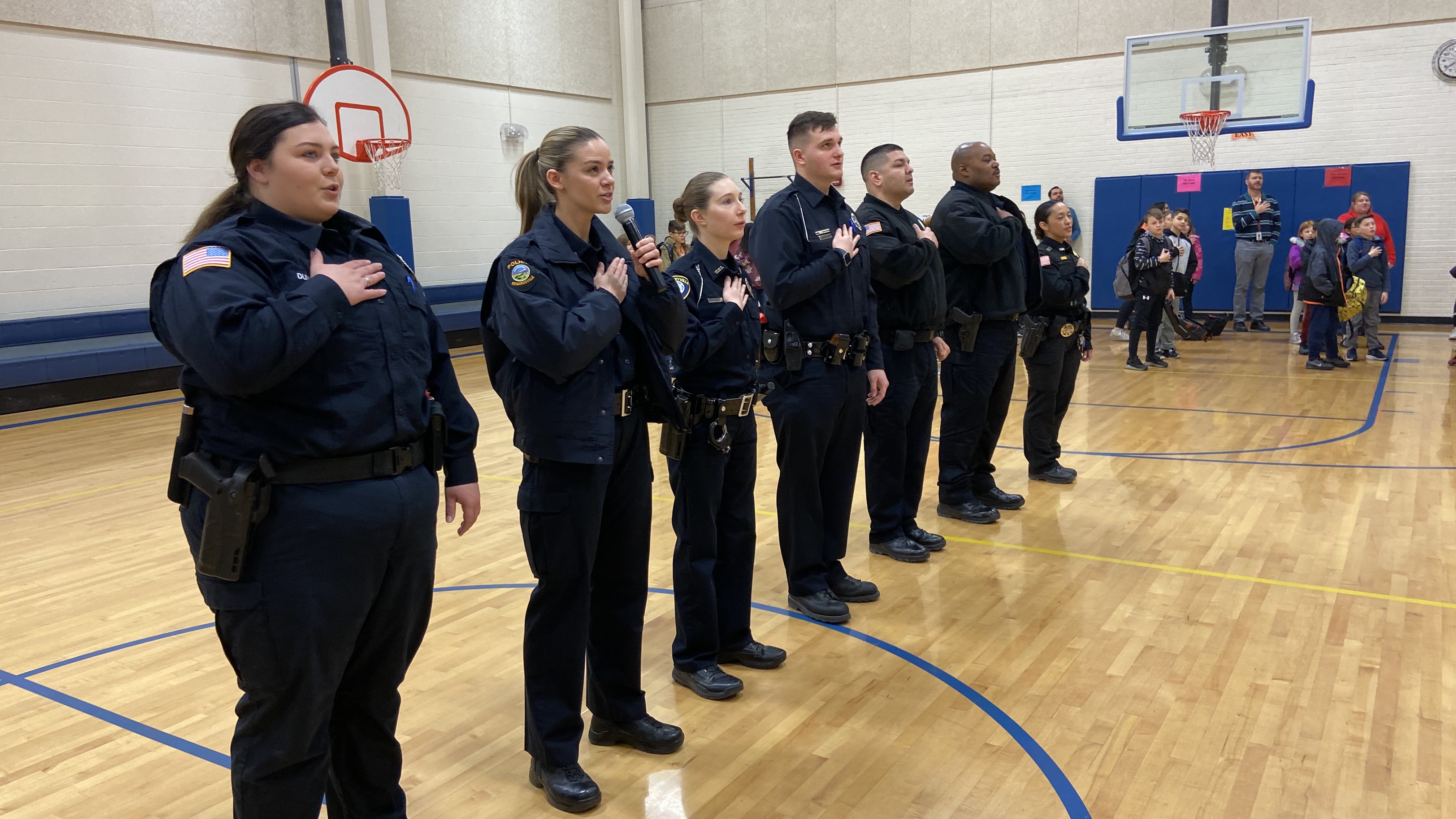 Officer Jennifer Richner of the Edwardsville Police Department leads the school in reciting the Pledge of Allegiance