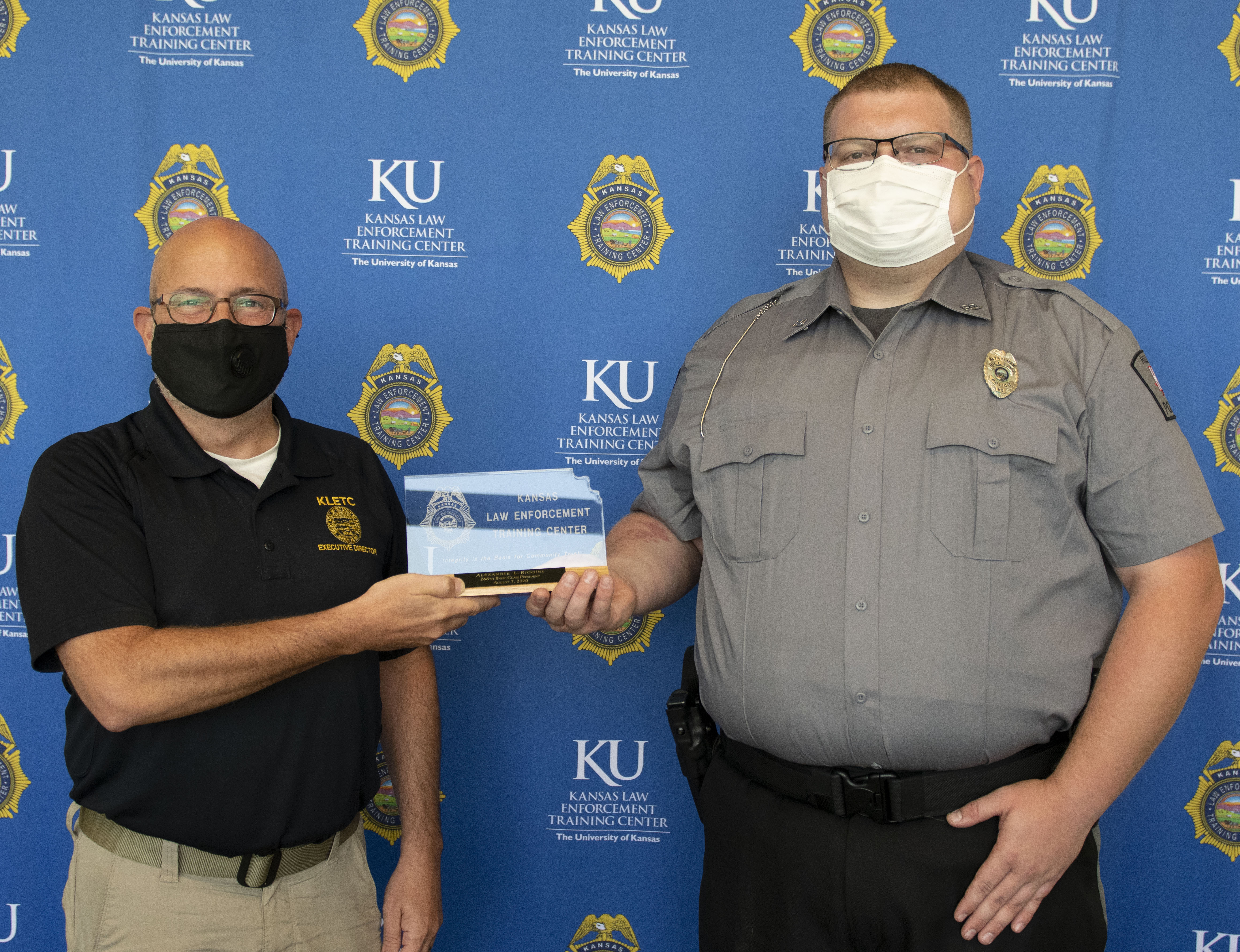 Class President Alexander Riggins of the Hill City Police Department holds his presidential plaque with KLETC Executive Director Darin Beck